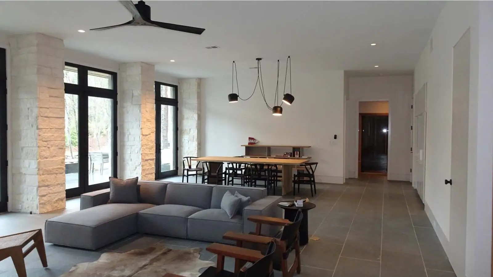 Open living and dining area in Lake Burton custom home with large windows and limestone walls