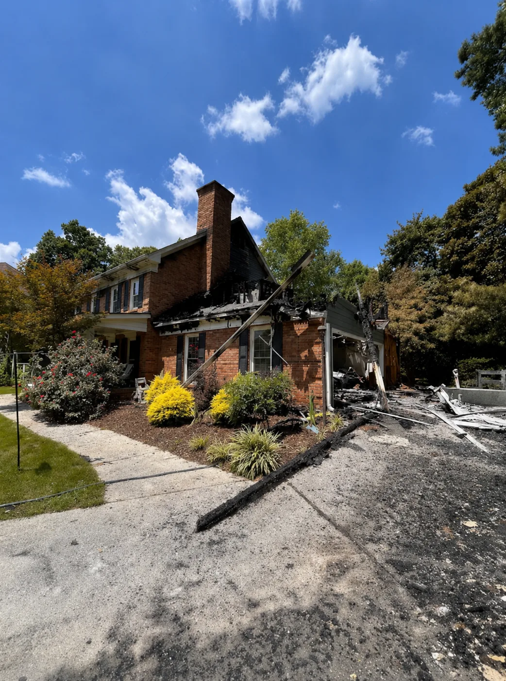 Fire-damaged brick home in Dunwoody, Georgia before major loss reconstruction by Eco Custom Homes